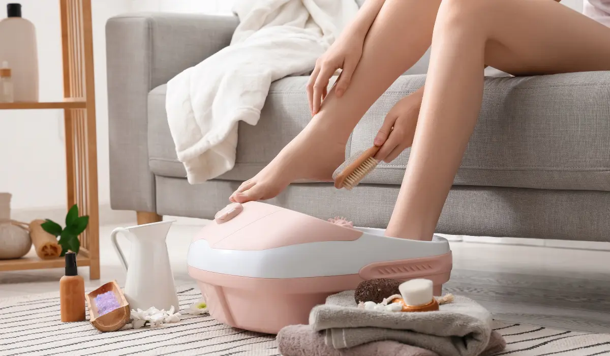 jeune femme dans son salon en train de faire un bain de pied maison