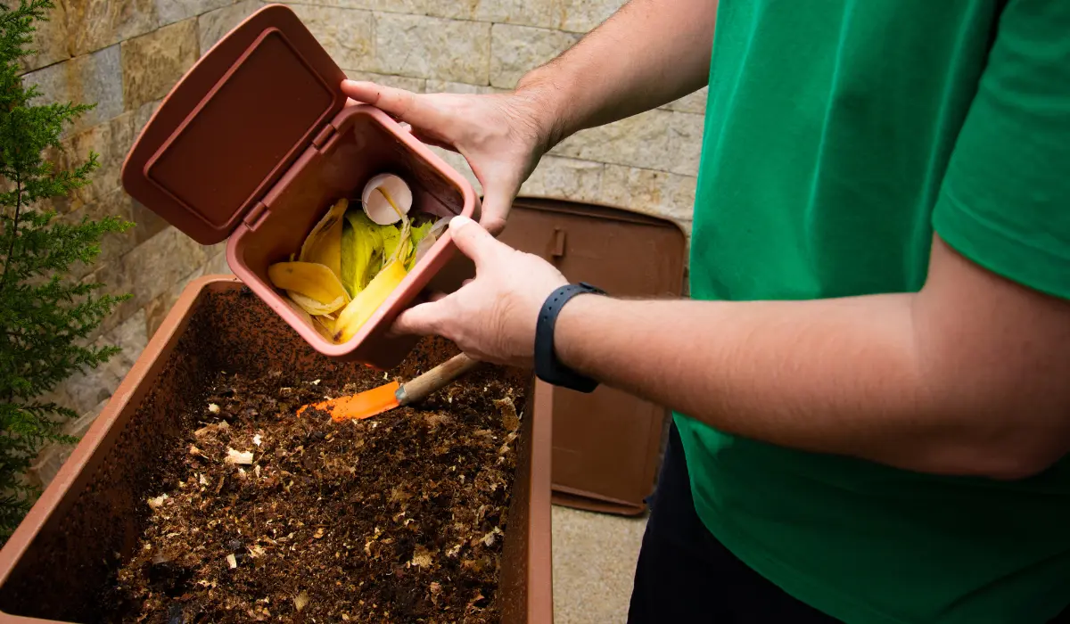 jeune homme en train de recycler ses déchets au jardin
