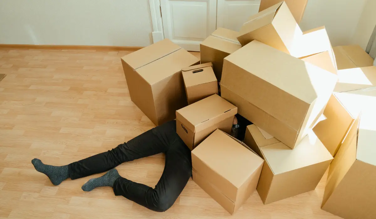 Un homme caché sur un fatras de carton