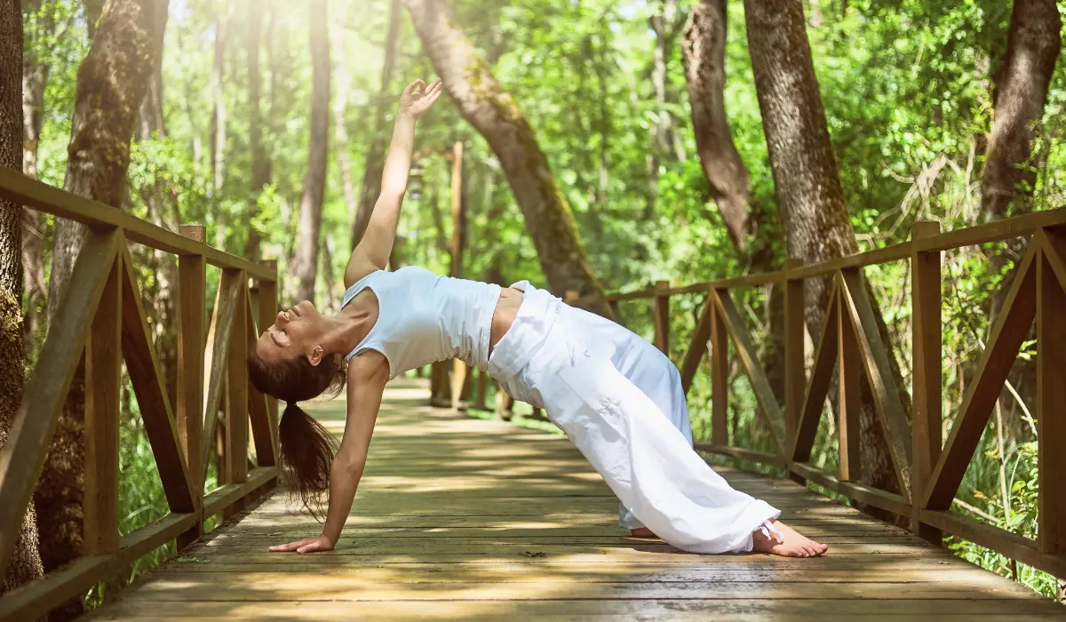 Femme réalisant une posture de yoga sur un pont